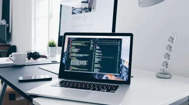 Website code on a laptop at a desk