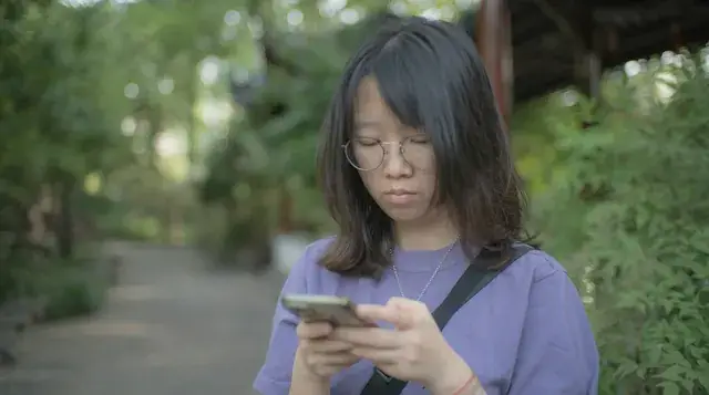 Young woman scrolling social media on her phone